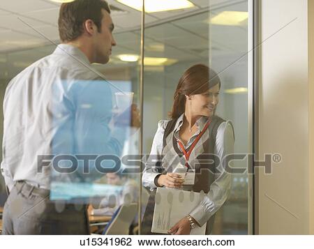 Stock Image - Office staff looking through window. Fotosearch