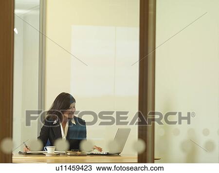 Stock Image - Office woman sitting at desk. Fotosearch
