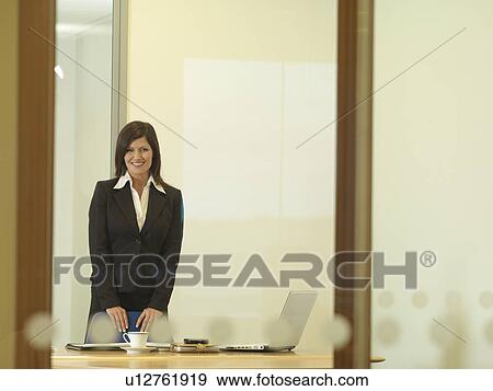Office woman standing at desk View Large Photo Image Stock Photo - Office woman standing at desk. Fotosearch