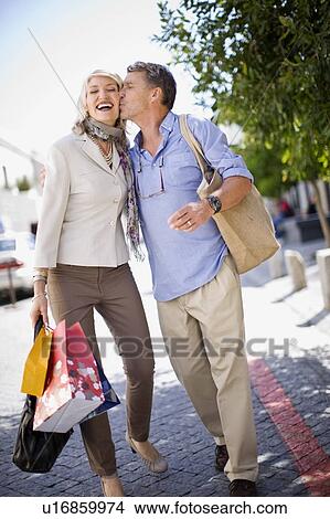 Older couple carrying shopping bags View Large Photo Image Picture - Older couple carrying shopping bags. Fotosearch