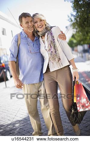 Older couple carrying shopping bags View Large Photo Image Stock Image - Older couple carrying shopping bags. Fotosearch