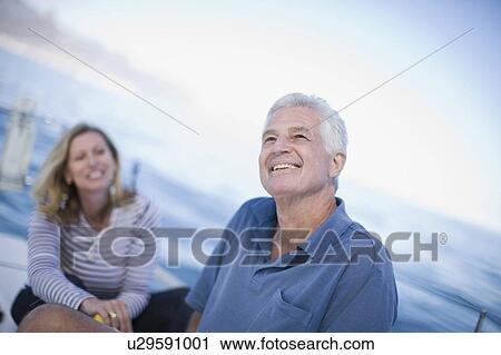 Stock Image - Older couple sitting on boat together. Fotosearch