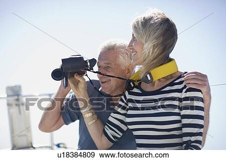 Older couple using binoculars on boat View Large Photo Image Stock Photo - Older couple using binoculars on boat. Fotosearch