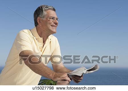 Older Man holding a newspaper View Large Photo Image Stock Photo - Older Man holding a newspaper . Fotosearch