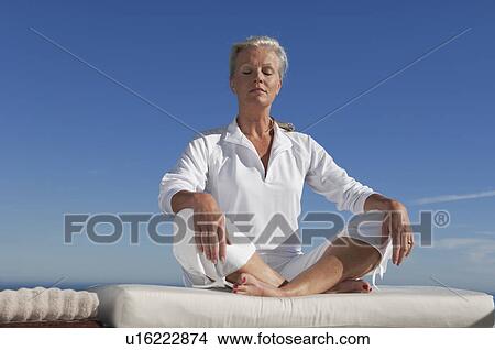 Picture - Older woman doing yoga. Fotosearch