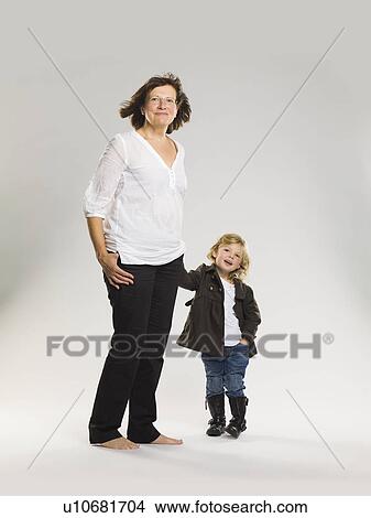 Picture - Older woman holding granddaughter’s hand. Fotosearch