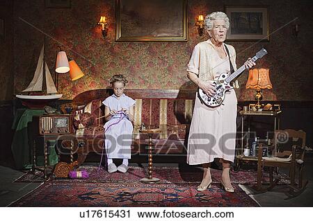 Older woman playing guitar as girl knits View Large Photo Image Stock Image - Older woman playing guitar as girl knits. Fotosearch