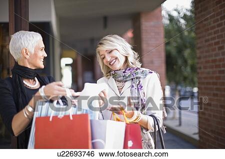 Older women carrying shopping bags View Large Photo Image Stock Photograph - Older women carrying shopping bags. Fotosearch