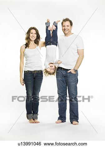 Stock Photograph - Parents holding daughter upside down. Fotosearch