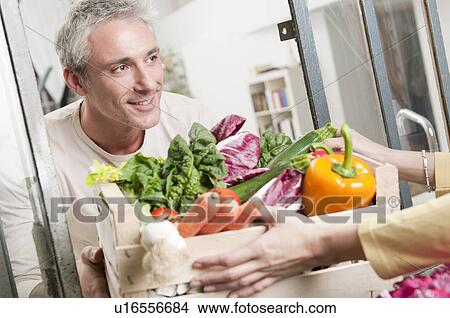 Picture - Passing a crate of organic vegetables. Fotosearch
