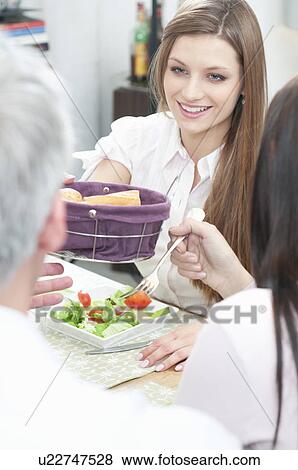 Stock Photo - Passing the bread at lunch. Fotosearch