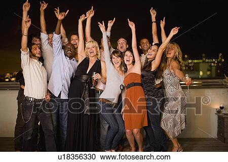People cheering at party at night View Large Photo Image Stock Image - People cheering at party at night. Fotosearch