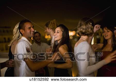 Stock Image - People dancing at party at night. Fotosearch