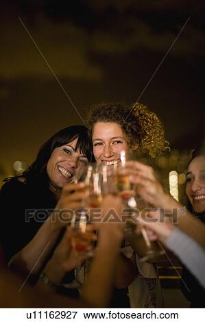 People toasting at party at night View Large Photo Image Stock Photo - People toasting at party at night. Fotosearch