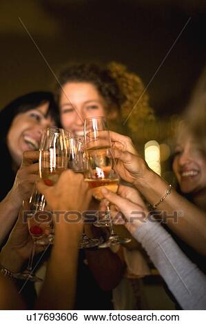 People toasting at party at night View Large Photo Image Stock Photograph - People toasting at party at night. Fotosearch