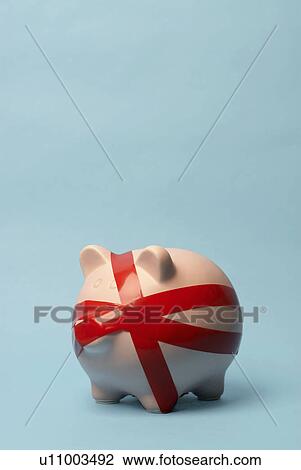 Stock Image - Piggy bank wrapped in red tape. Fotosearch