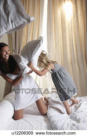 Stock Photo - Pillow fight between mother and daughter. Fotosearch