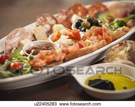 Stock Image - Plate of antipasto in restaurant. Fotosearch
