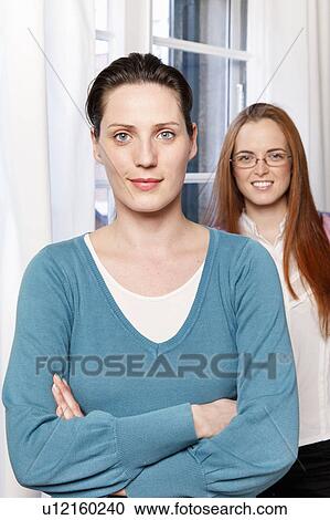 Stock Image - Portrait of 2 women in a office. Fotosearch