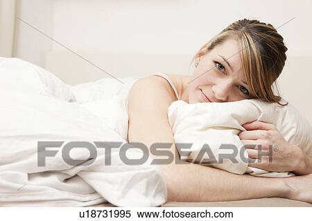 Portrait of young woman in bed View Large Photo Image Stock Photography - Portrait of young woman in bed. Fotosearch