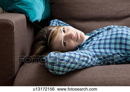 Portrait of young woman on a sofa View Large Photo Image Stock Photograph - Portrait of young woman on a sofa. Fotosearch