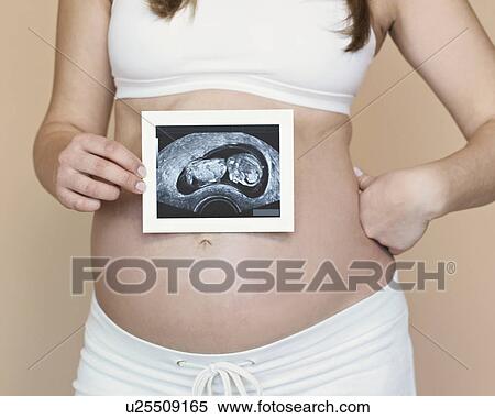 Stock Photography - Pregnancy bump with ultra sound image. Fotosearch