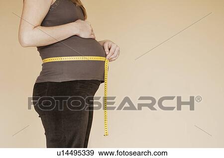 Pregnancy bump with with measuring tape, profile View Large Photo Image Stock Photo - Pregnancy bump with with measuring tape, profile. Fotosearch