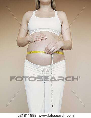 Pregnancy bump with with measuring tape View Large Photo Image Stock Photo - Pregnancy bump with with measuring tape. Fotosearch
