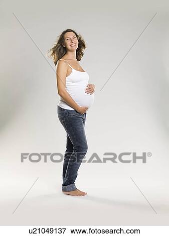 Stock Photo - Pregnant woman holding belly. Fotosearch
