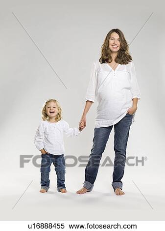 Stock Photography - Pregnant woman holding daughter’s hand. Fotosearch