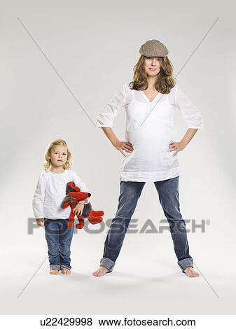 Pregnant woman standing with daughter View Large Photo Image Stock Photo - Pregnant woman standing with daughter. Fotosearch
