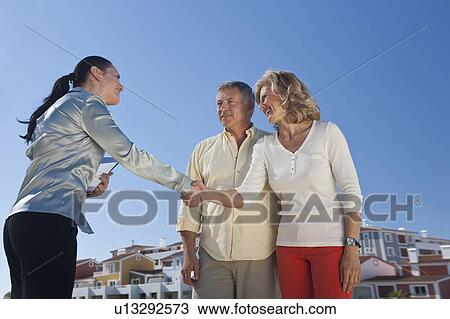 Realestate agent greeting mature couple View Large Photo Image Stock Image - Realestate agent greeting mature couple. Fotosearch