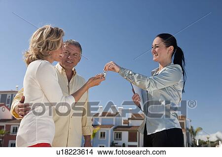 Picture - Realestate agent handing keys to couple. Fotosearch