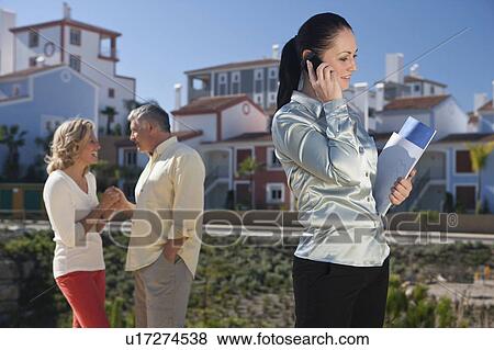 Realestate agent talking on mobile phone View Large Photo Image Stock Photo - Realestate agent talking on mobile phone. Fotosearch