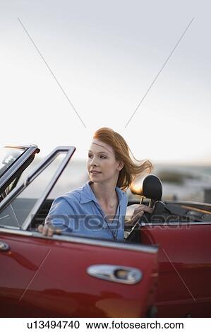 Red haired girl sittin in red car View Large Photo Image Stock Image - Red haired girl sittin in red car. Fotosearch