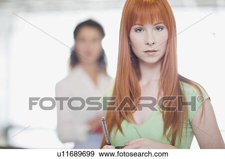 Red-haired woman holding pen View Large Photo Image Stock Photo - Red-haired woman holding pen. Fotosearch