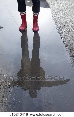 Reflection of a woman in a puddle View Large Photo Image Stock Photo - Reflection of a woman in a puddle. Fotosearch