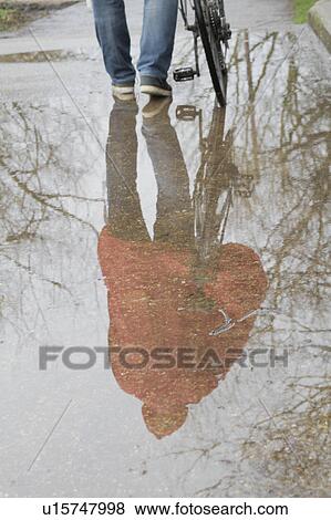 Reflection of man with bicycle in puddle View Large Photo Image Stock Photo - Reflection of man with bicycle in puddle. Fotosearch
