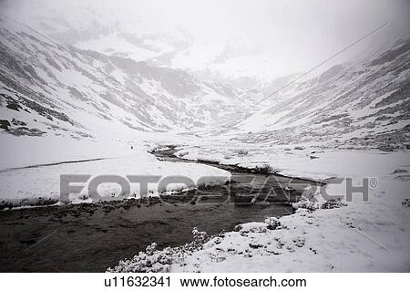 Stock Image - River in snowy mountainscape. Fotosearch