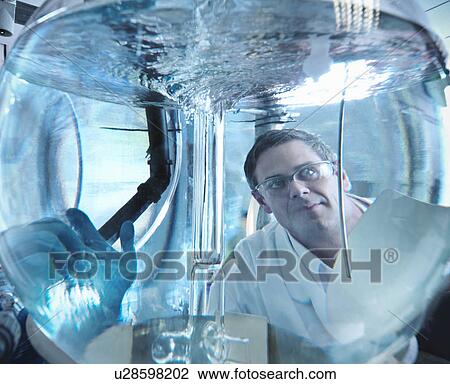 Scientist looking through mixing vessel View Large Photo Image Stock Image - Scientist looking through mixing vessel. Fotosearch