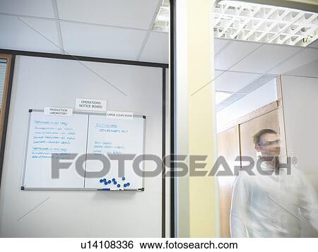 Stock Photograph - Scientist next to noticeboard. Fotosearch