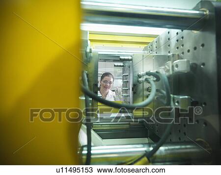 Stock Image - Scientist with plastic moulding machine. Fotosearch