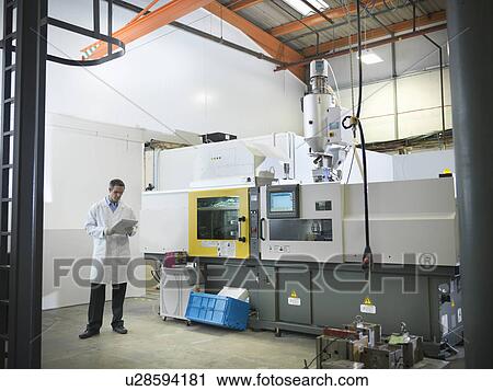 Stock Image - Scientist with plastic moulding machine. Fotosearch