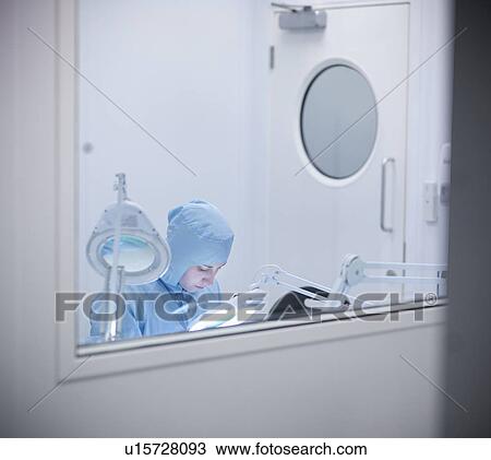 Stock Image - Scientist working in clean room. Fotosearch