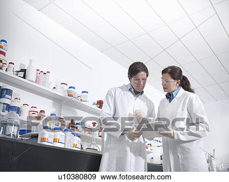 Scientists discussing findings in lab View Large Photo Image Stock Photo - Scientists discussing findings in lab. Fotosearch
