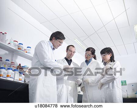 Scientists discussing findings in lab View Large Photo Image Stock Photo - Scientists discussing findings in lab. Fotosearch