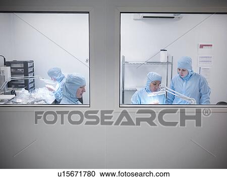 Stock Image - Scientists in clean room working. Fotosearch