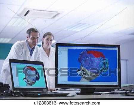 Stock Image - Scientists look at CAD drawings. Fotosearch