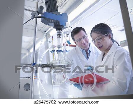 Stock Image - Scientists with experiment in laboratory. Fotosearch