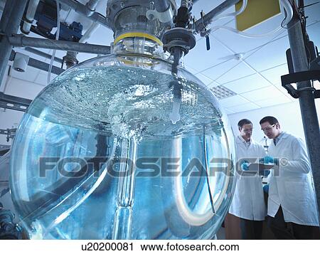 Stock Image - Scientists with laboratory mixing vessel. Fotosearch